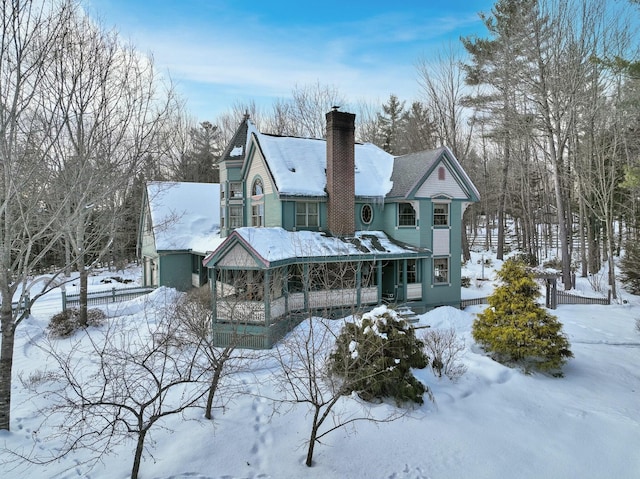 view of front of property with a garage, a porch, and a chimney