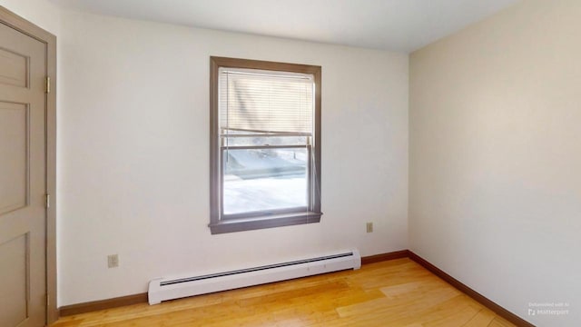 spare room with a baseboard heating unit and light hardwood / wood-style floors