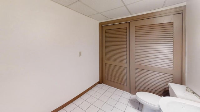 bathroom featuring a paneled ceiling and toilet