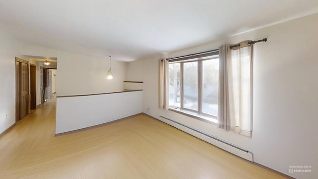 unfurnished room with parquet flooring and a baseboard heating unit