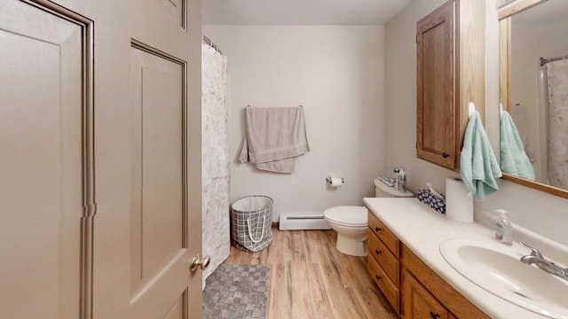 bathroom featuring hardwood / wood-style floors, curtained shower, a baseboard radiator, vanity, and toilet