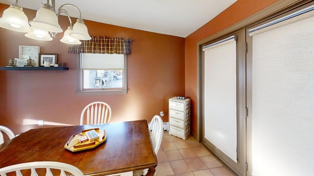 tiled dining area with a chandelier