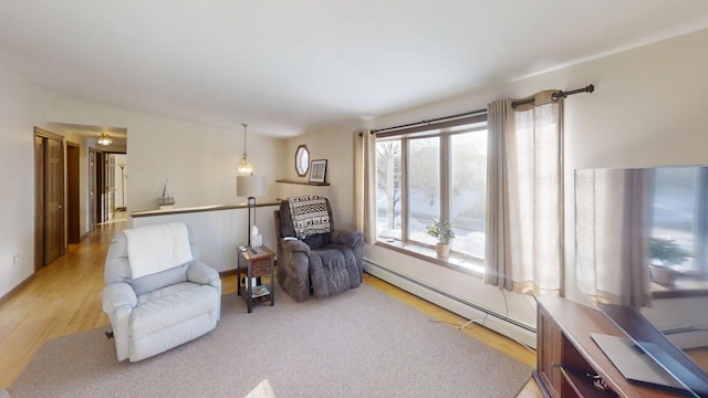 living area with light wood-type flooring and baseboard heating