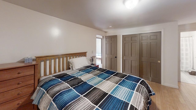 bedroom featuring connected bathroom, hardwood / wood-style flooring, and a closet