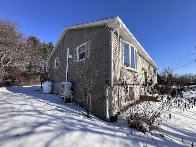 snow covered property with ac unit