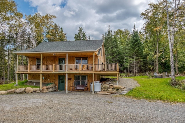 view of front facade featuring a wooden deck and a front yard