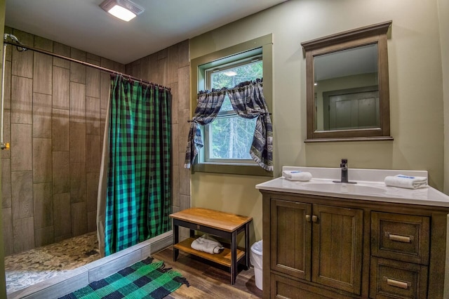 bathroom with hardwood / wood-style flooring, a shower with curtain, toilet, and vanity