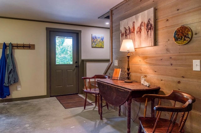 foyer with wood walls and concrete flooring