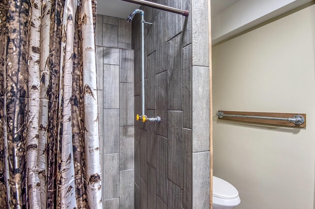 bathroom with a shower with shower curtain and toilet