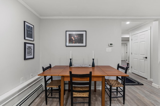 dining area with baseboard heating, hardwood / wood-style floors, and ornamental molding