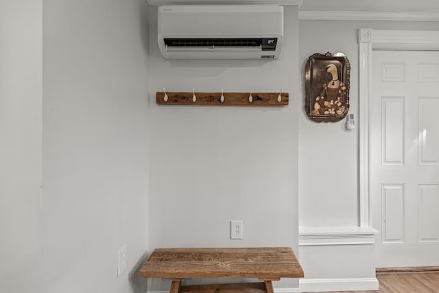 interior details featuring a wall unit AC and crown molding