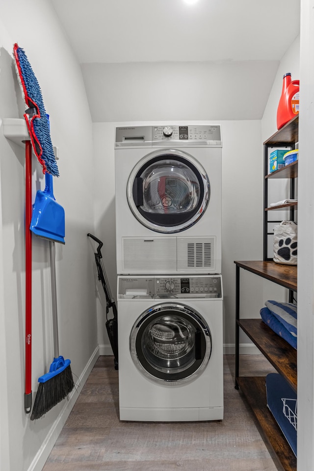 clothes washing area with stacked washer and clothes dryer and hardwood / wood-style flooring