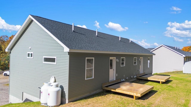 back of property featuring a deck and a yard