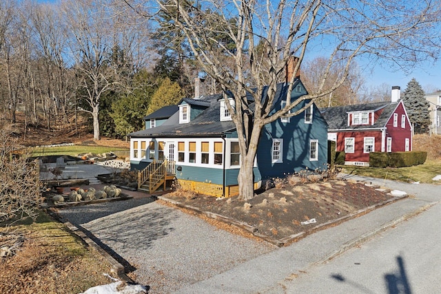 cape cod house featuring a sunroom