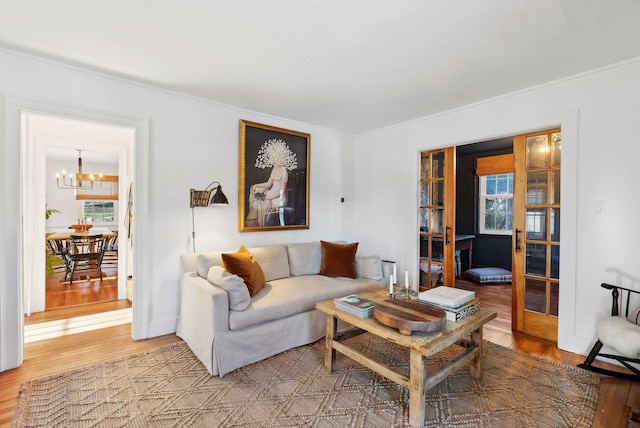 living room featuring french doors, wood-type flooring, and a chandelier