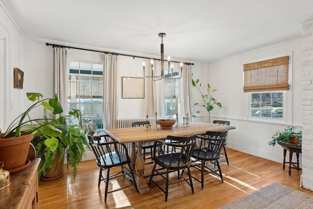 dining space featuring light wood-type flooring and an inviting chandelier