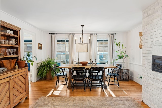 dining room featuring a fireplace, light hardwood / wood-style flooring, and a wealth of natural light