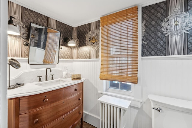 bathroom with vanity, radiator, and toilet