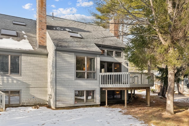 snow covered rear of property featuring a deck