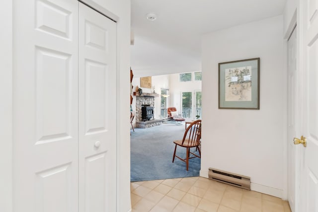 hallway featuring baseboard heating and light carpet