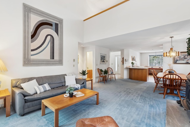 carpeted living room with an inviting chandelier