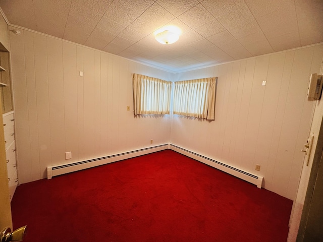 spare room featuring baseboard heating and wooden walls