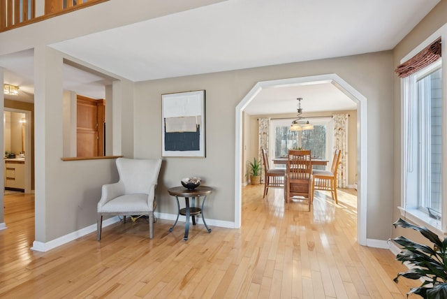 living area featuring light wood-type flooring and a notable chandelier