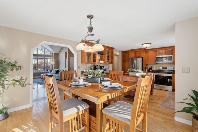 dining space featuring vaulted ceiling and light hardwood / wood-style floors