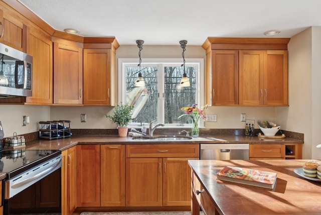 kitchen with sink, pendant lighting, wooden counters, and appliances with stainless steel finishes