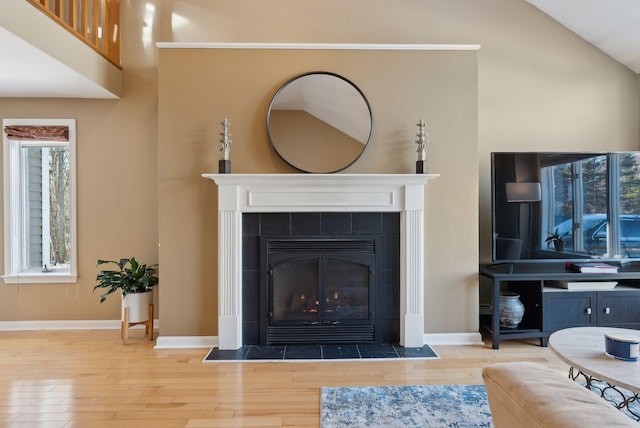 living room with hardwood / wood-style floors, lofted ceiling, and a fireplace