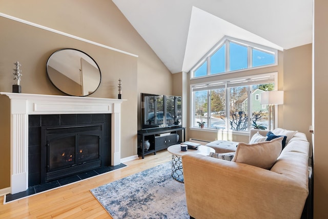 living room with a fireplace, hardwood / wood-style floors, a wealth of natural light, and baseboard heating