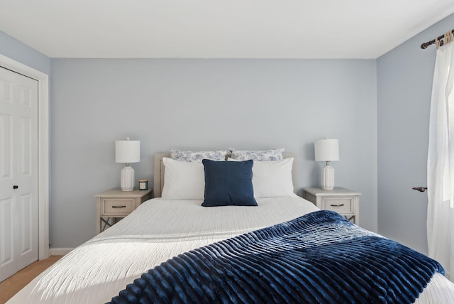 bedroom with light colored carpet and a closet