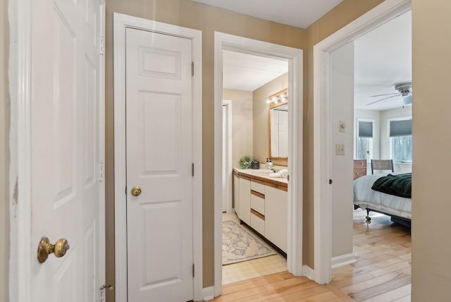 hall with light hardwood / wood-style flooring and sink