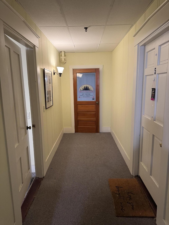 63 Main St, Bucksport, ME 04416 - corridor with a paneled ceiling, dark colored carpet, baseboards, and a decorative wall