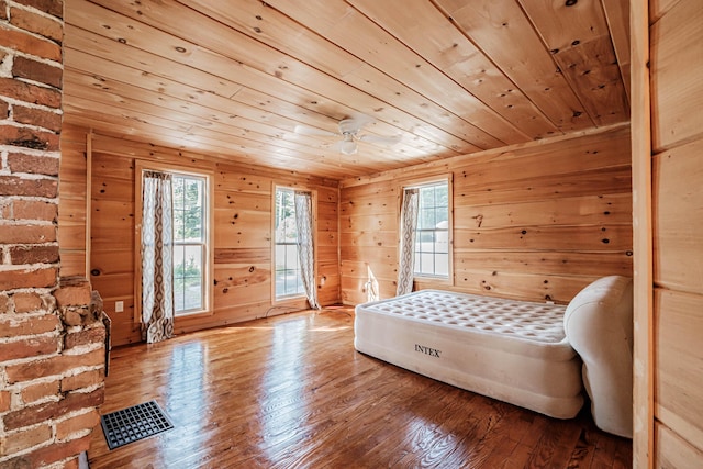 bedroom with hardwood / wood-style flooring, wooden ceiling, and wooden walls