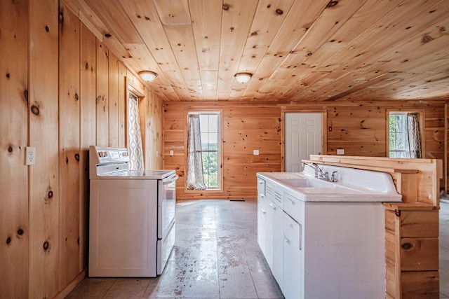 kitchen featuring wooden walls, a kitchen island with sink, white cabinets, wood ceiling, and range