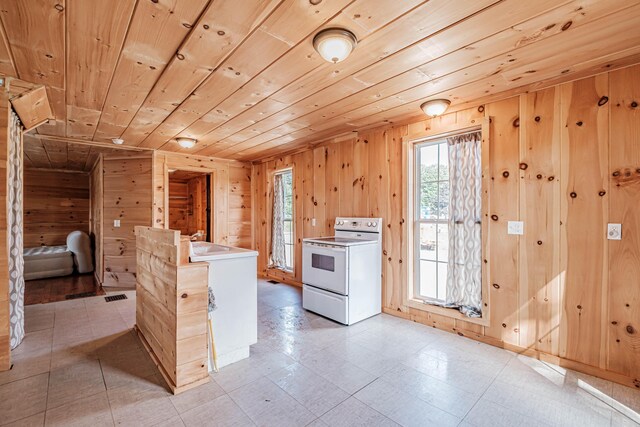 kitchen featuring electric range, refrigerator, wood ceiling, and wood walls