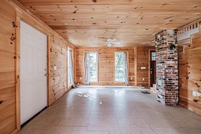 interior space with wooden walls, ceiling fan, wooden ceiling, and lofted ceiling