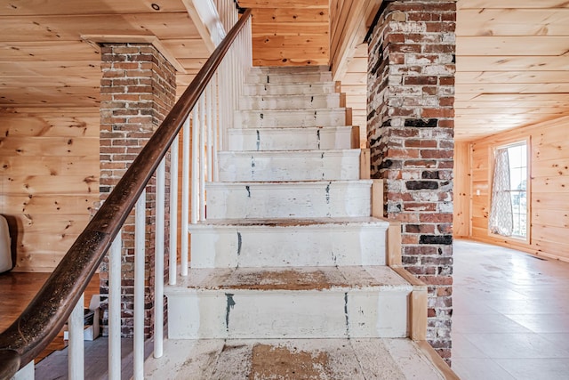 staircase featuring wooden ceiling and wooden walls