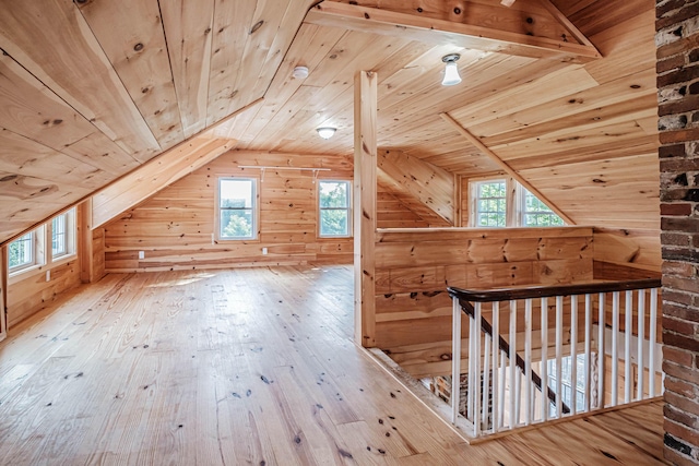 additional living space with hardwood / wood-style floors, vaulted ceiling, wooden ceiling, and wood walls