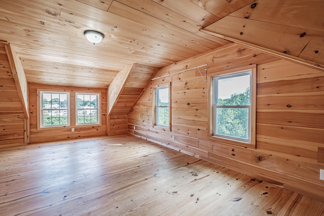 additional living space featuring wood-type flooring, wood ceiling, wooden walls, and vaulted ceiling