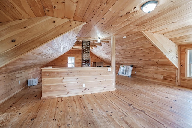 additional living space featuring wooden walls, hardwood / wood-style floors, wooden ceiling, and lofted ceiling