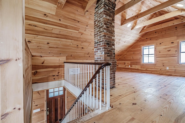 additional living space with vaulted ceiling with beams, wood walls, hardwood / wood-style floors, and wooden ceiling