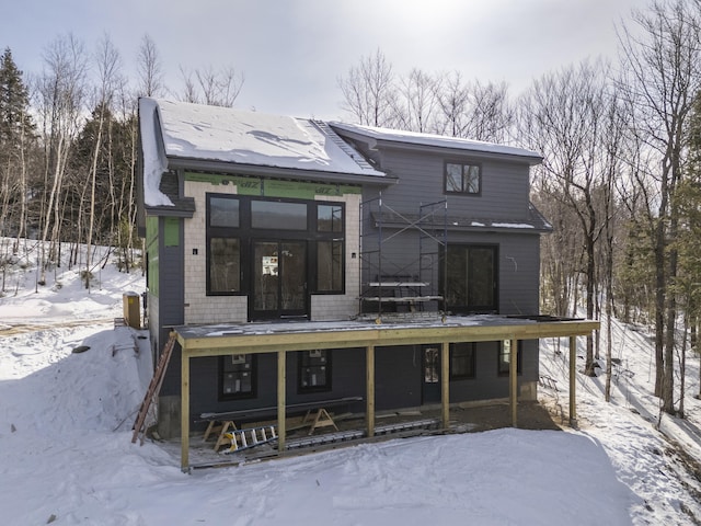 snow covered house featuring french doors