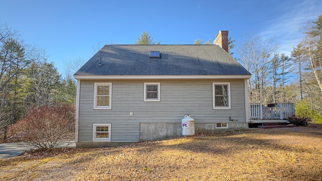 22 Jewett Rd, Raymond, ME 04071 - rear view of property featuring roof with shingles, a deck, and a chimney
