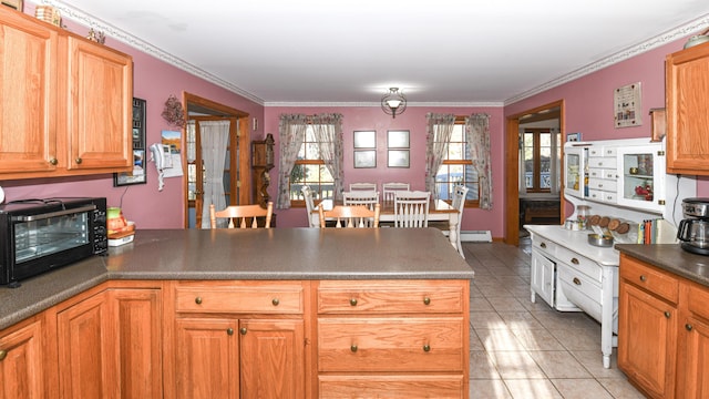 22 Jewett Rd, Raymond, ME 04071 - kitchen featuring a toaster, a peninsula, crown molding, dark countertops, and light tile patterned flooring