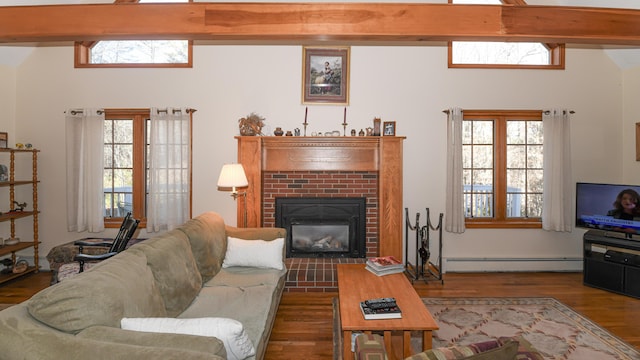 22 Jewett Rd, Raymond, ME 04071 - living room featuring a baseboard radiator, wood finished floors, beamed ceiling, and a brick fireplace