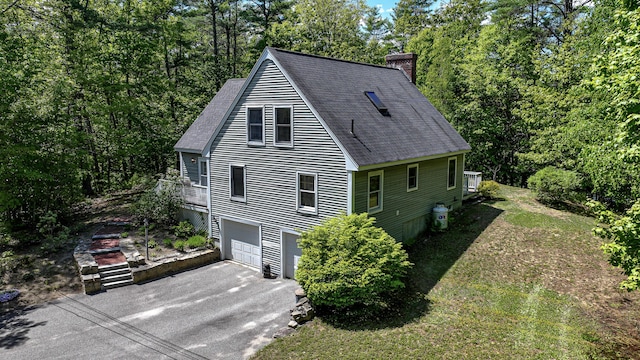 22 Jewett Rd, Raymond, ME 04071 - view of home's exterior featuring asphalt driveway, a chimney, roof with shingles, and a garage