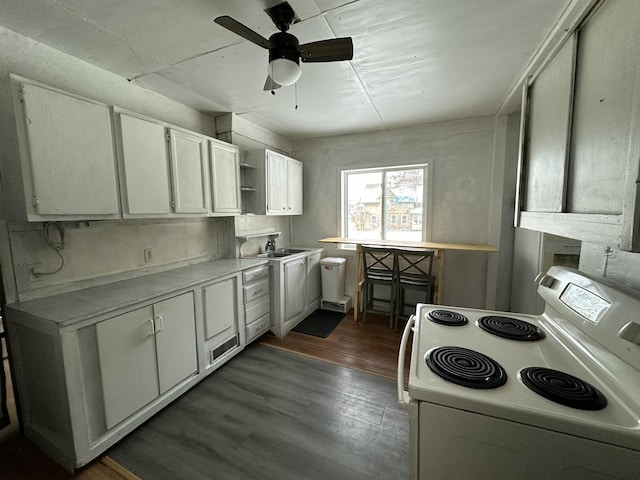 kitchen featuring sink, dark hardwood / wood-style flooring, electric stove, ceiling fan, and white cabinets