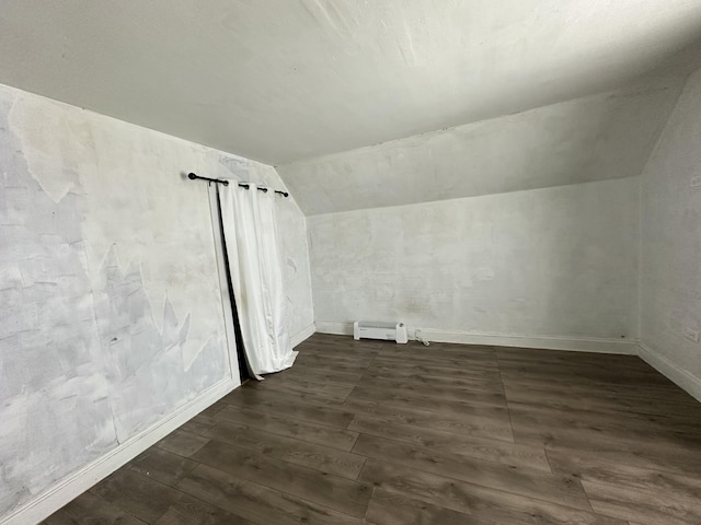 additional living space featuring lofted ceiling, dark wood-type flooring, and baseboard heating